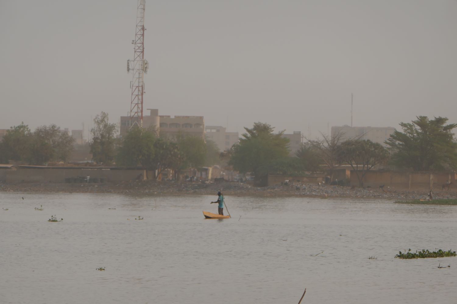 Un pêcheur est en train de récupérer ses filets de pêche sur le barrage nº 2 de Ouagadougou © Globe Reporters