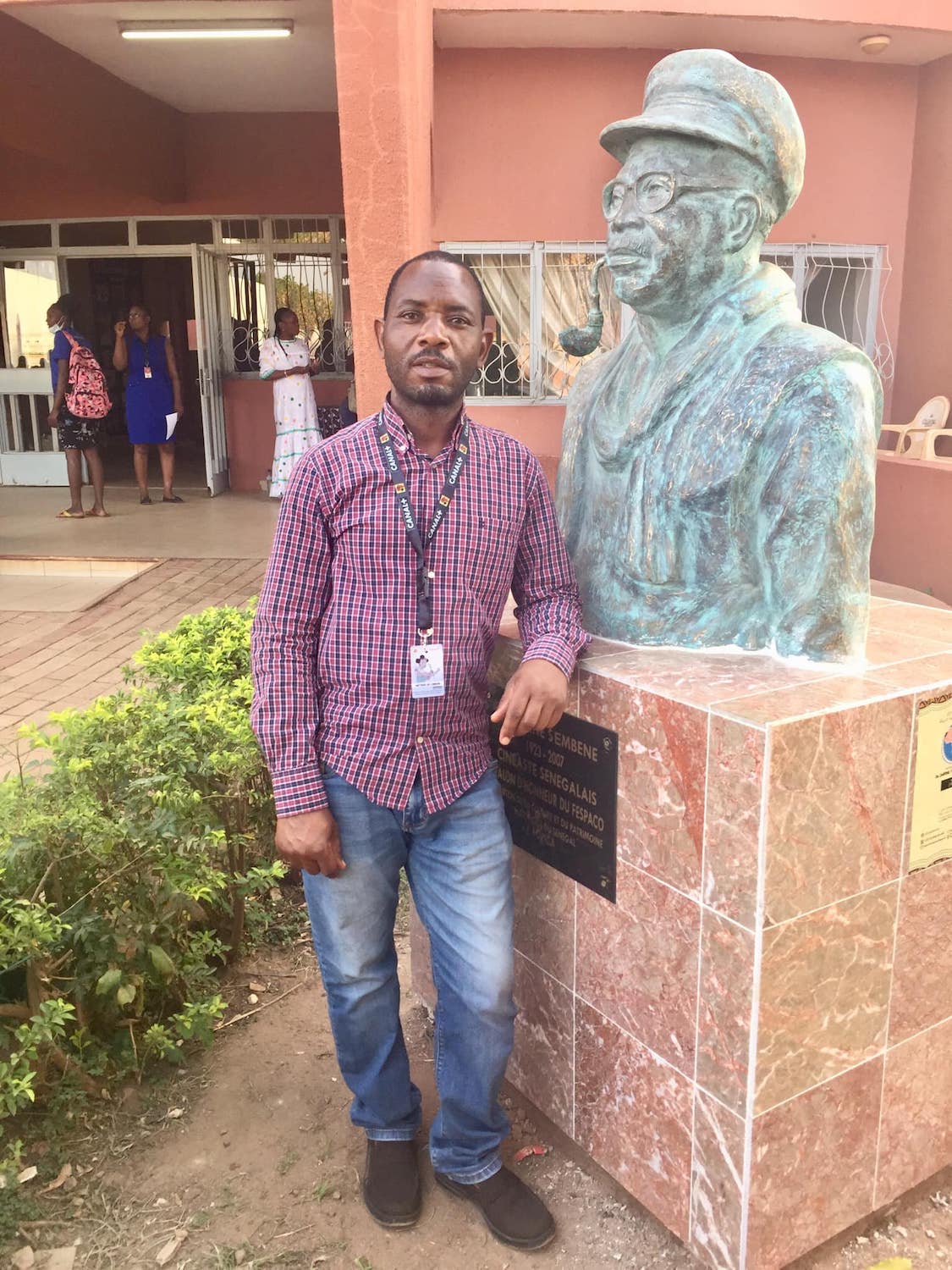 TD Jack au siège du FESPACO à côté du buste d’Ousmane SEMBENE, acteur, réalisateur, écrivain, qui est considéré « le père du cinéma africain » © Globe Reporters
