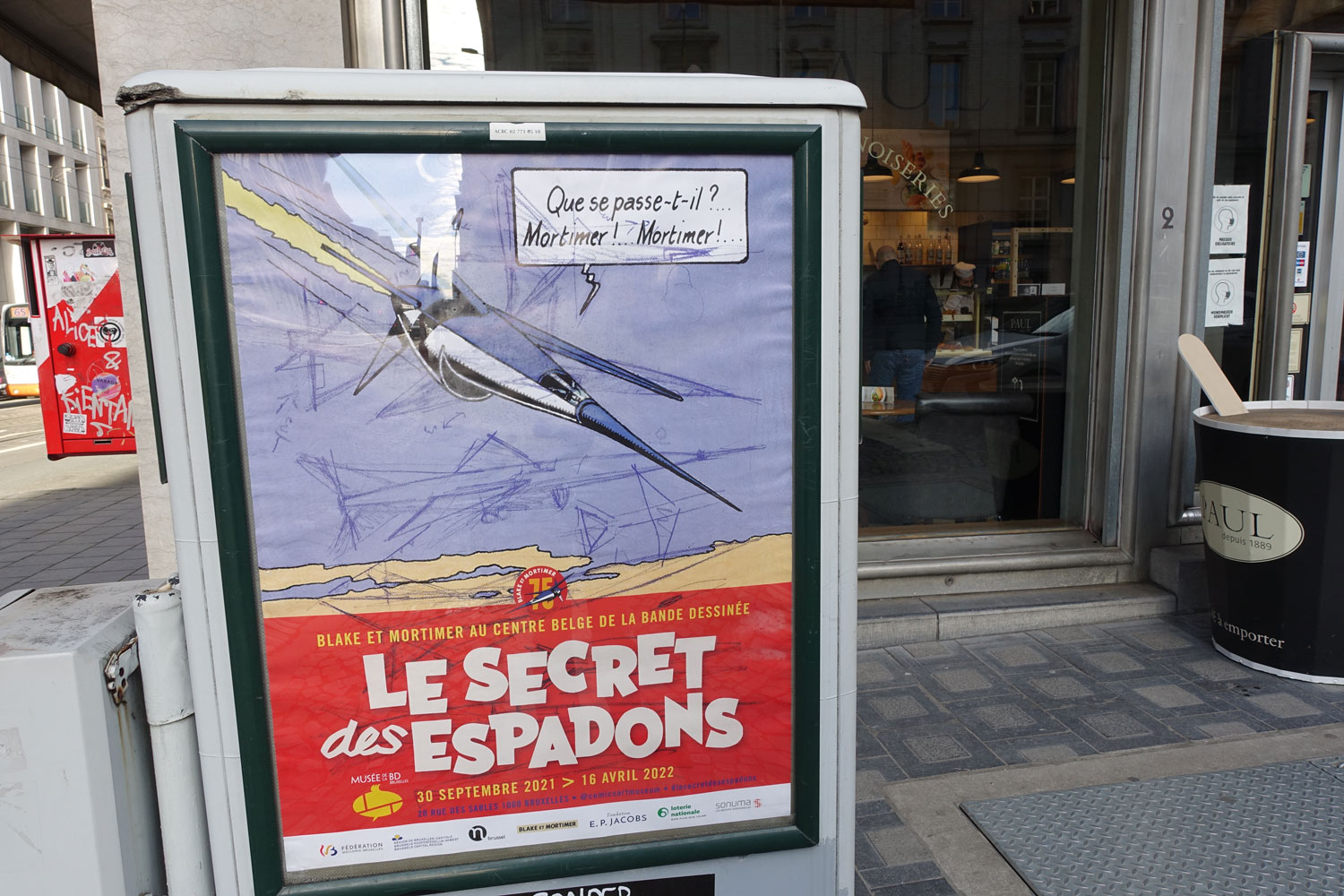Devant le journal, une publicité pour une bande dessinée comme on en croise beaucoup à Bruxelles © Globe Reporters