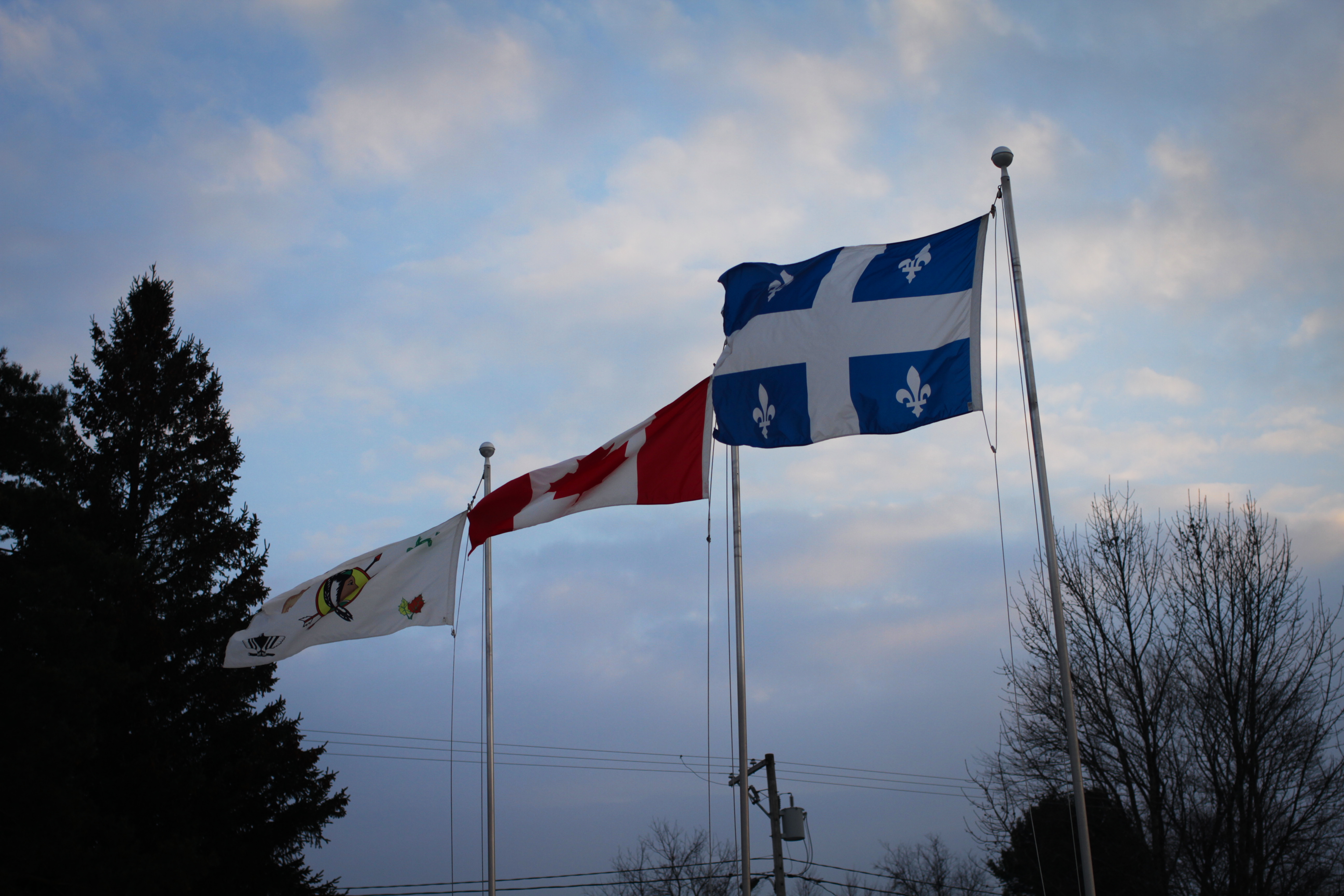 Drapeaux devant le conseil : drapeau du Québec, drapeau du Canada et drapeau de la nation abénakise.
