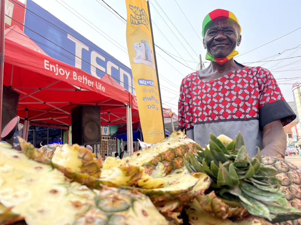 François, vendeur d’ananas à Douala, supporter des Lions indomptables, l’équipe nationale de football du Cameroun © Globe Reporters