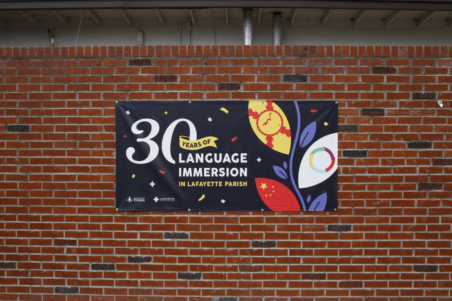 Sur un mur extérieur du lycée : « 30 ans d’immersion dans la paroisse de Lafayette. » © Globe Reporters