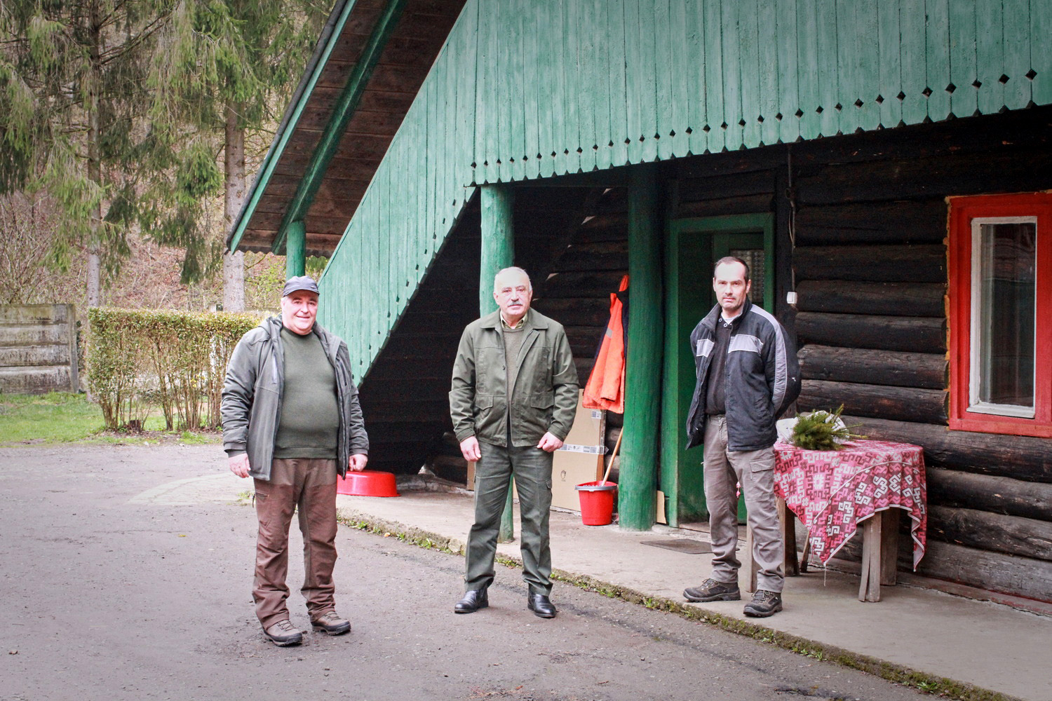 Adrian, Petru et un autre garde-forestier devant la maison de Petru © Globe Reporters