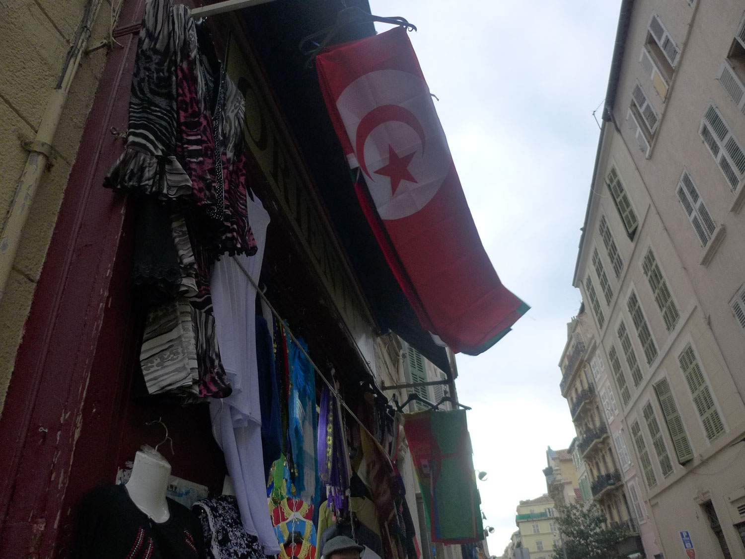 Un drapeau tunisien plane dans une ruelle.