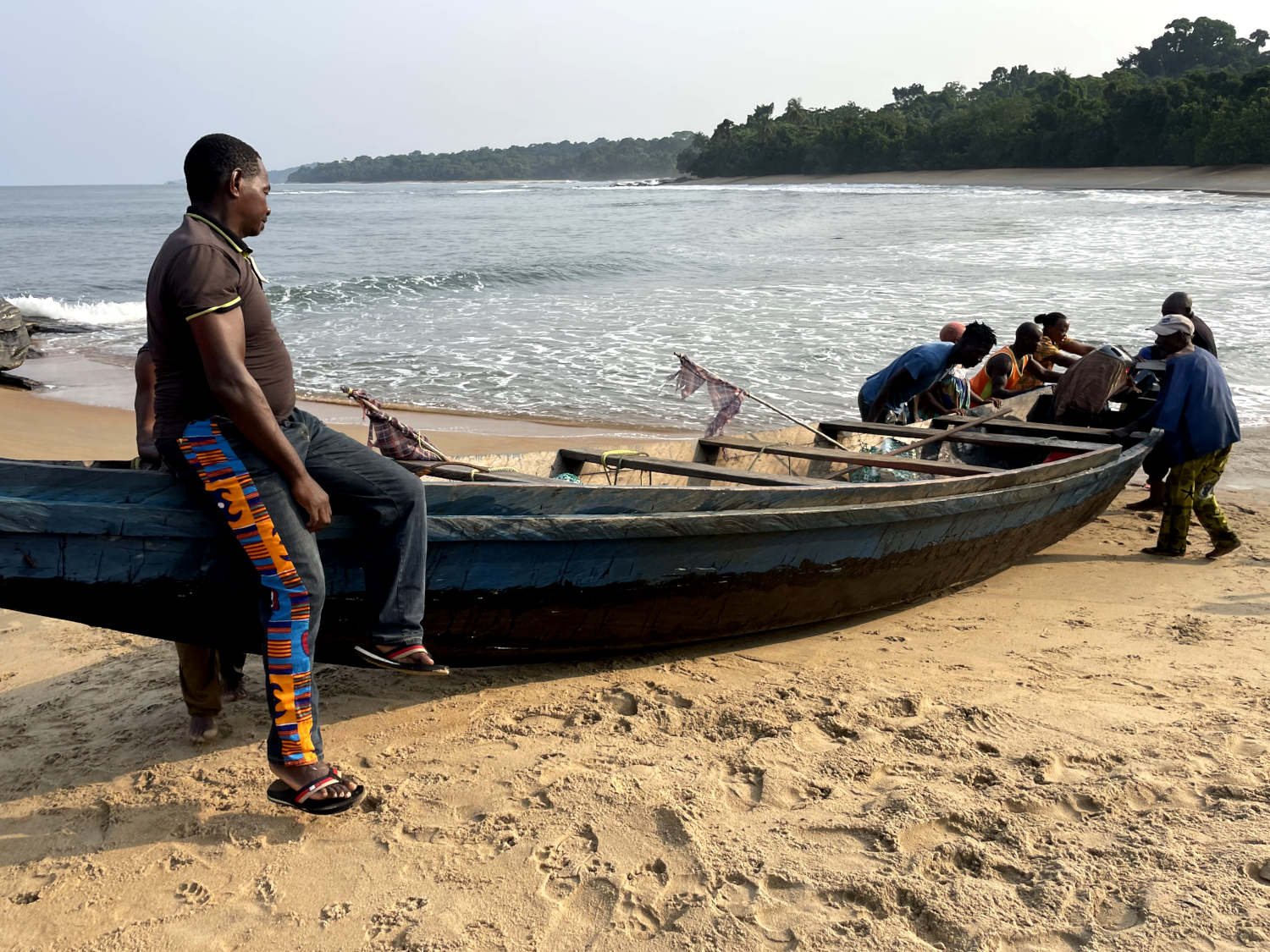 De retour sur la terre ferme, tout le monde se mobilise pour aider à remonter la pirogue de plusieurs centaines de kilos sur la plage © Globe Reporters