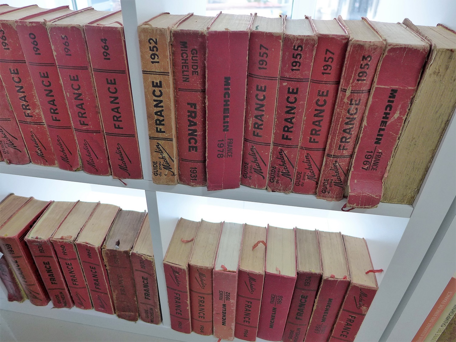 Dans un coin de la cuisine, une bibliothèque avec de vieux exemplaires du guide Michelin, une grande référence en matière de gastronomie.