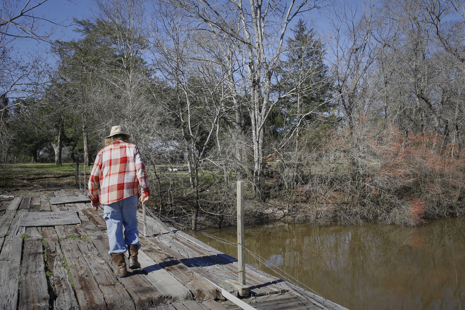 Bobby traverse un pont qui l’emmène à son terrain près de bayou Bourbeux © Globe Reporters