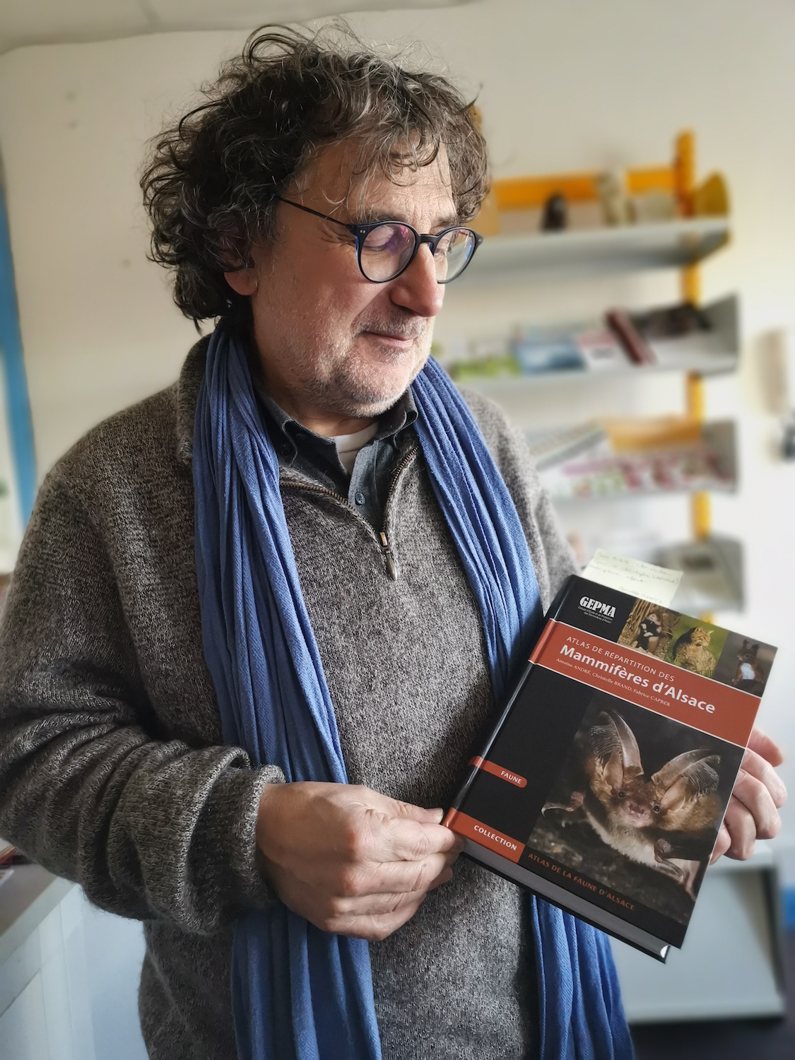 Bruno ULRICH pose avec un livre dans lequel il a écrit le chapitre sur les chauves-souris © Globe Reporters