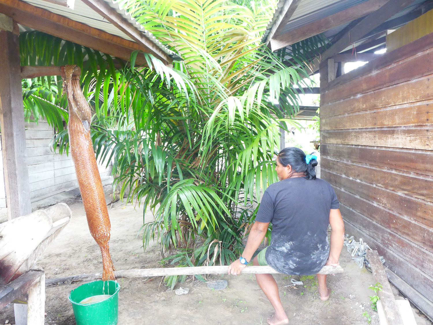 Lina en pleine action de pressage de la purée de manioc.