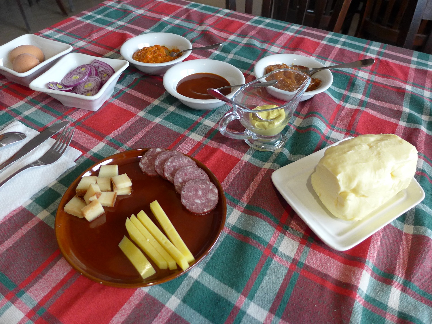 Petit déjeuner traditionnel à la pension La Ferma : pain, confiture, beurre, mais aussi fromage, oignons, saucisson, etc.