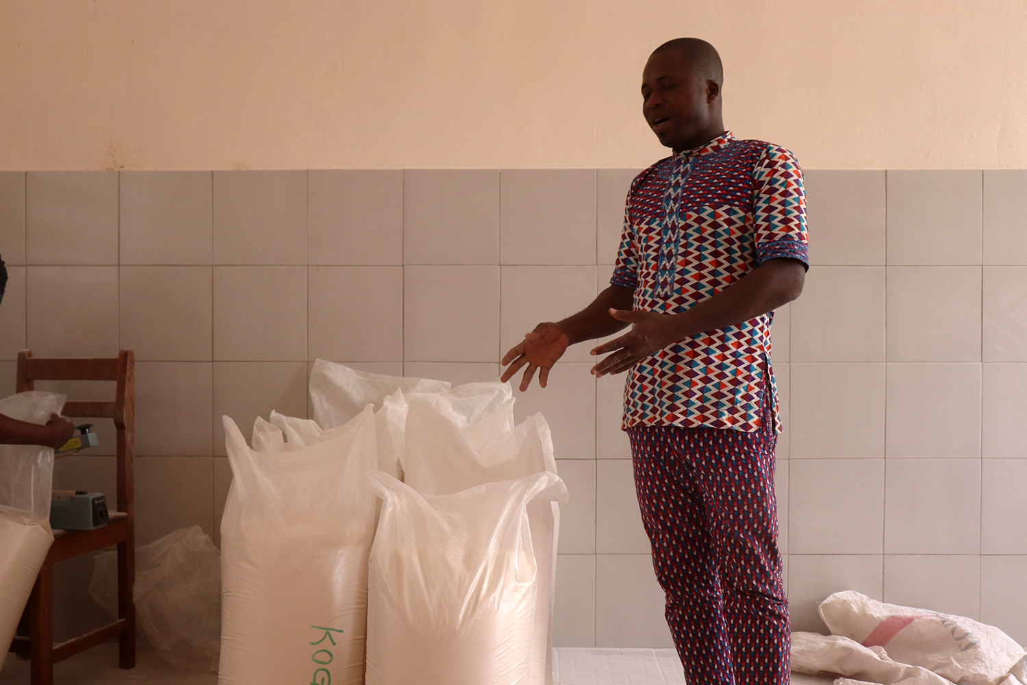 Jacob KANABA montre les sacs de farine prêts pour la commercialisation. 