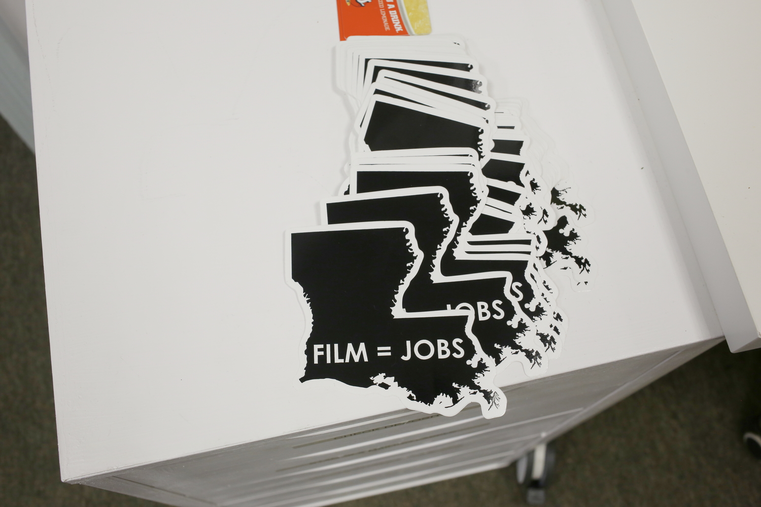 Autocollants qui représentent l’État de Louisiane avec écrit dessus : « Films = du travail » © Globe Reporters