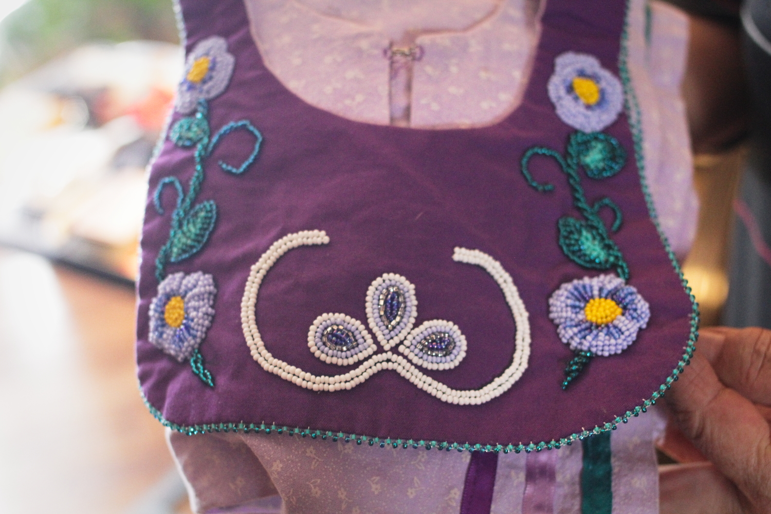 Une robe de perle tissée par Donna O’BOMSAWIN pour sa petite-fille, moitié Abénakise et moitié Mohawk. Les deux demi-cercles sont un symbole abénaki tandis que l’autre forme de tissage (plus épais) est mohawk.