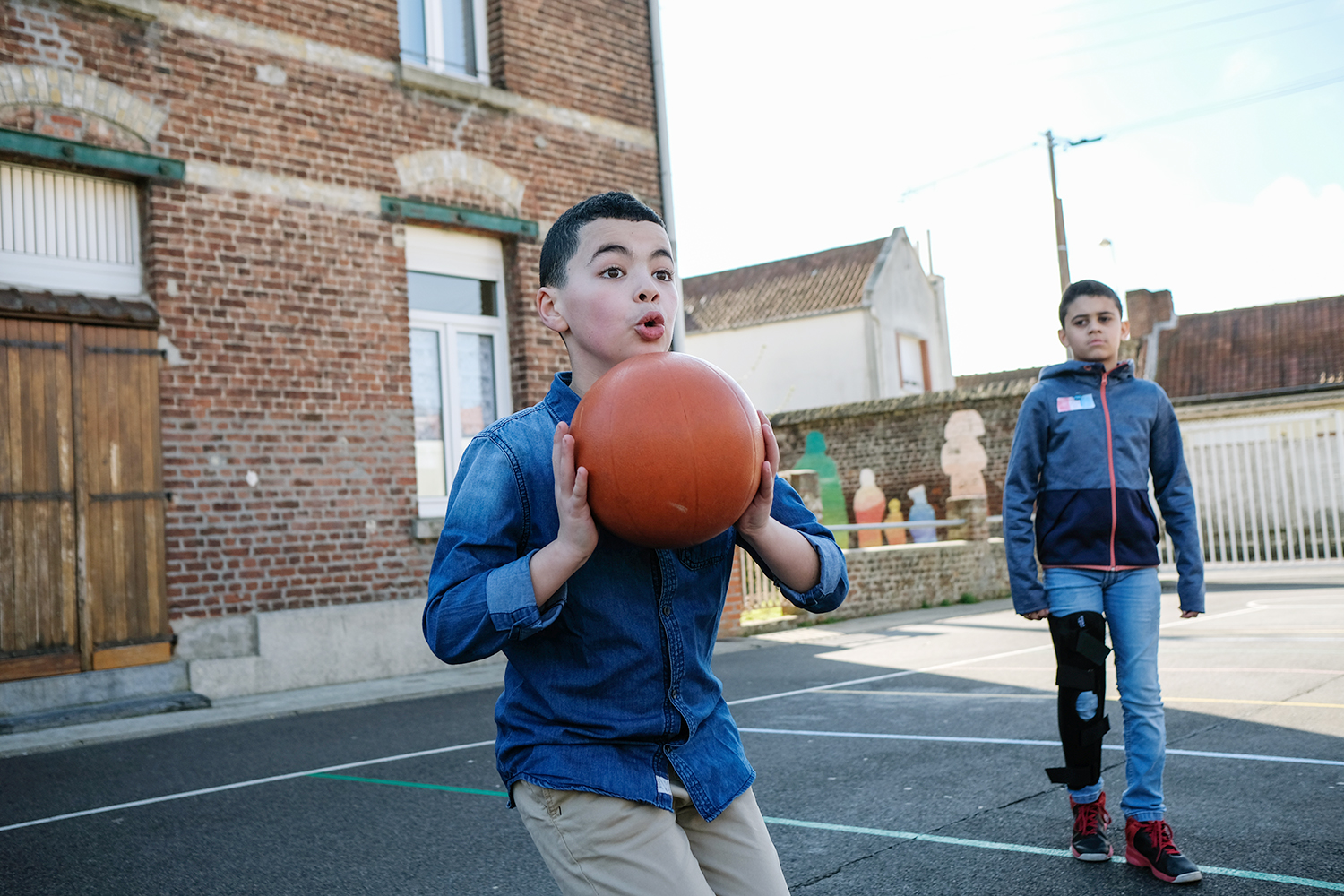 Pendant la récréation, les garçons occupent le terrain de basket.