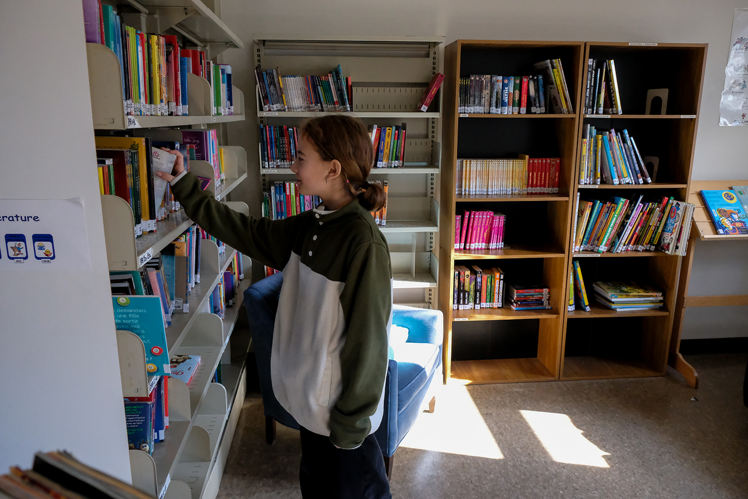 Toujours dans la bibliothèque, Clara présente la belle collection de livres ! © Globe Reporters