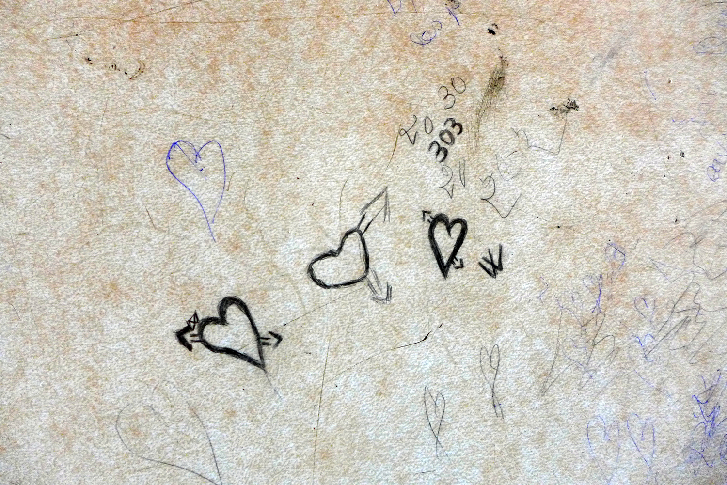 Des graffitis sur une table d’écolier
