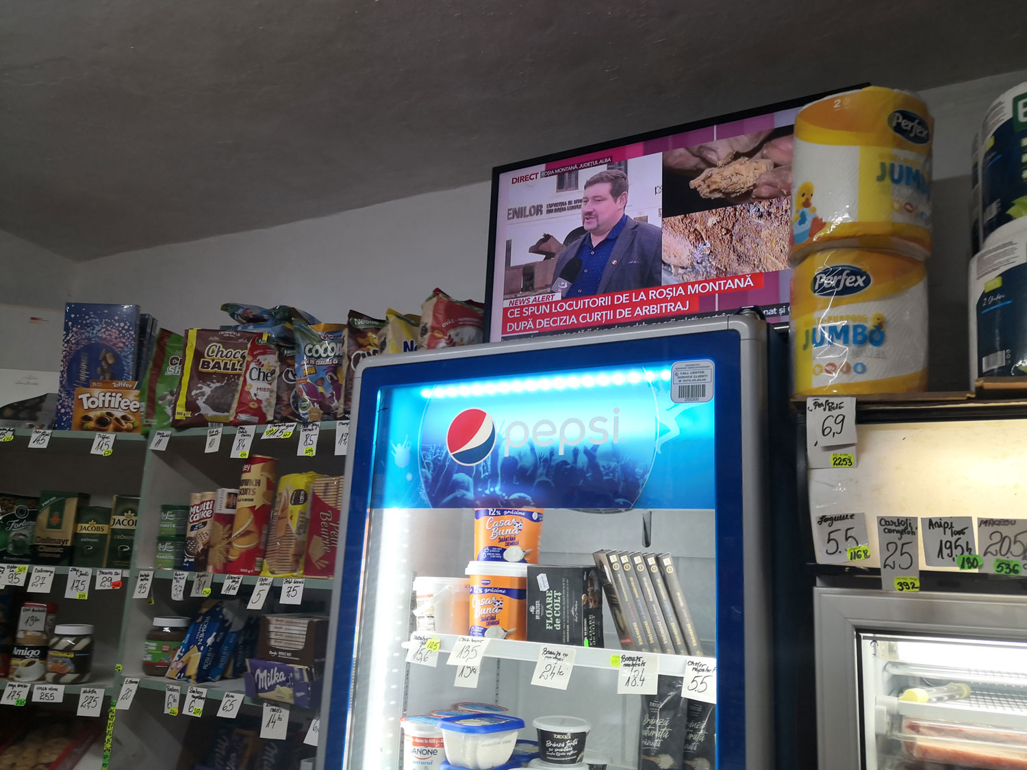 Dans le magasin sur la place de Roşia montana, les clients, émus, ont bien entendu les yeux rivés sur ce qui se filme dehors © Globe Reporters 