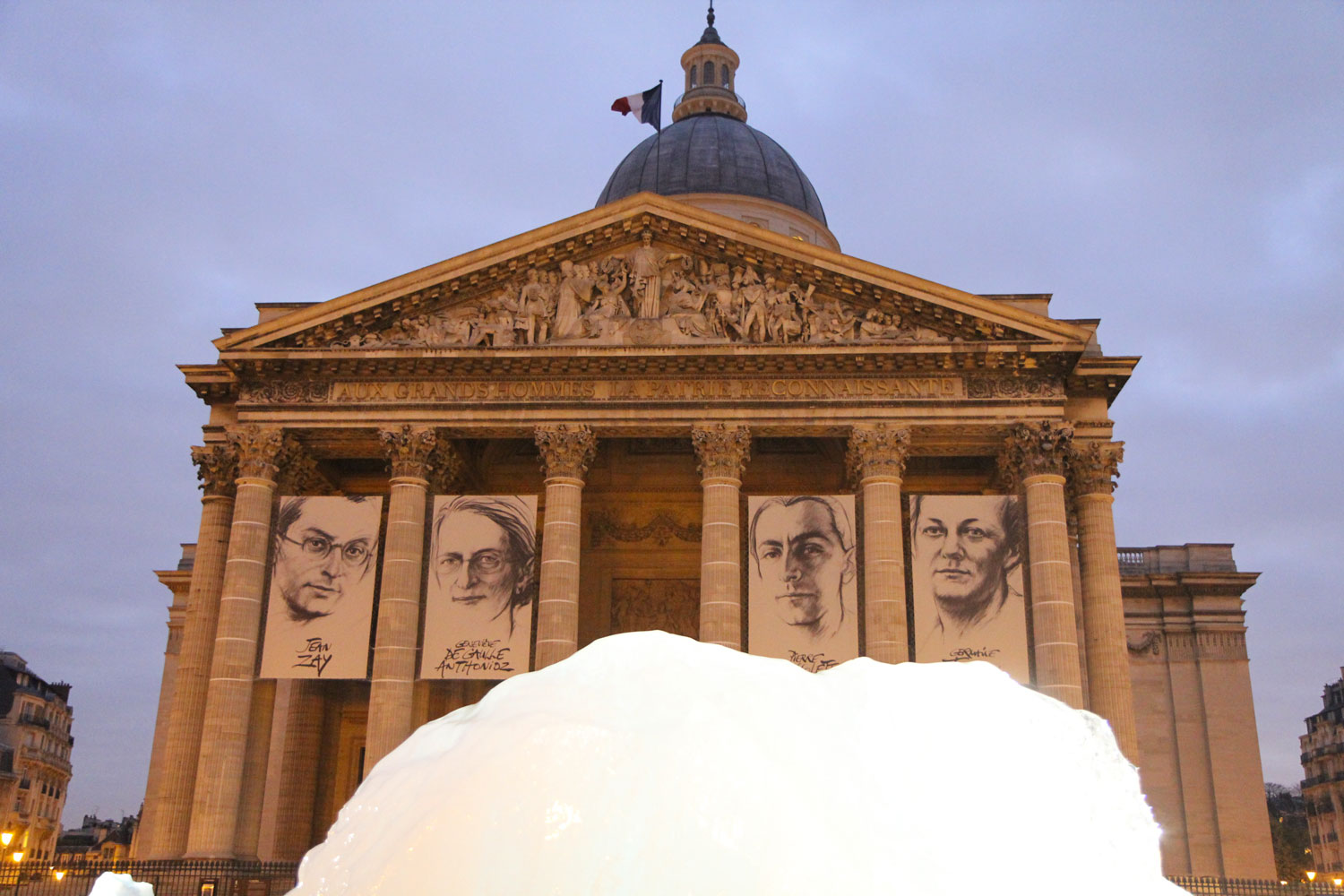 Place du Panthéon, les blocs de glace de « Ice Watch » sous le portrait des quatre dernières personnalités admises au Panthéon. Crédit Valérie Rohart. Crédit Valérie Rohart