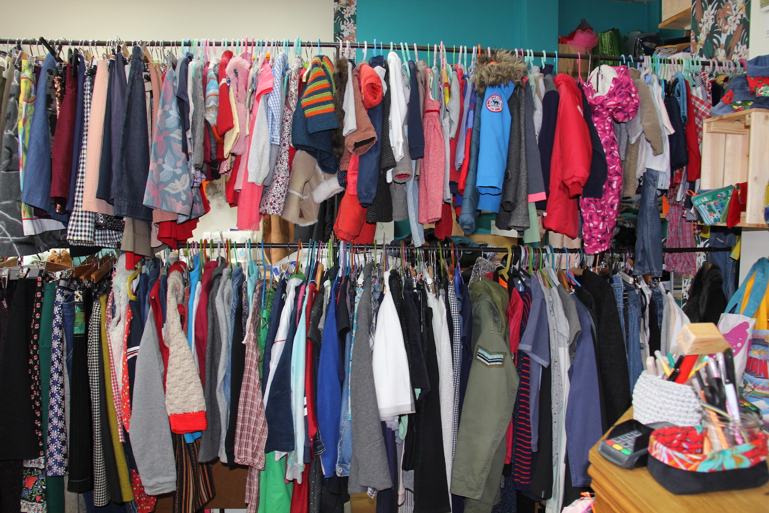 Les deux portants de vêtements pour enfants servent de séparation entre la partie vente et atelier de couture © Globe Reporters
