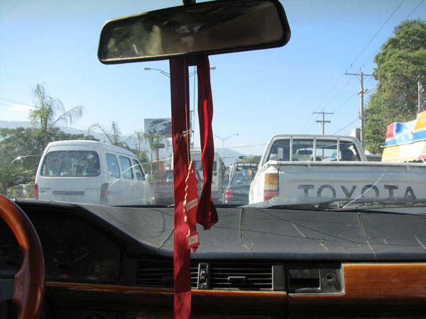 Pour cette première ballade, je prends un taxi. Mais comment reconnaître un taxi à Port au Prince ? Facile ! Il faut regarder la plaque d’immatriculation arrière. Si il est écrit TP (transport public), c’est un taxi. Autre signe ; un ruban rouge attaché au rétroviseur.